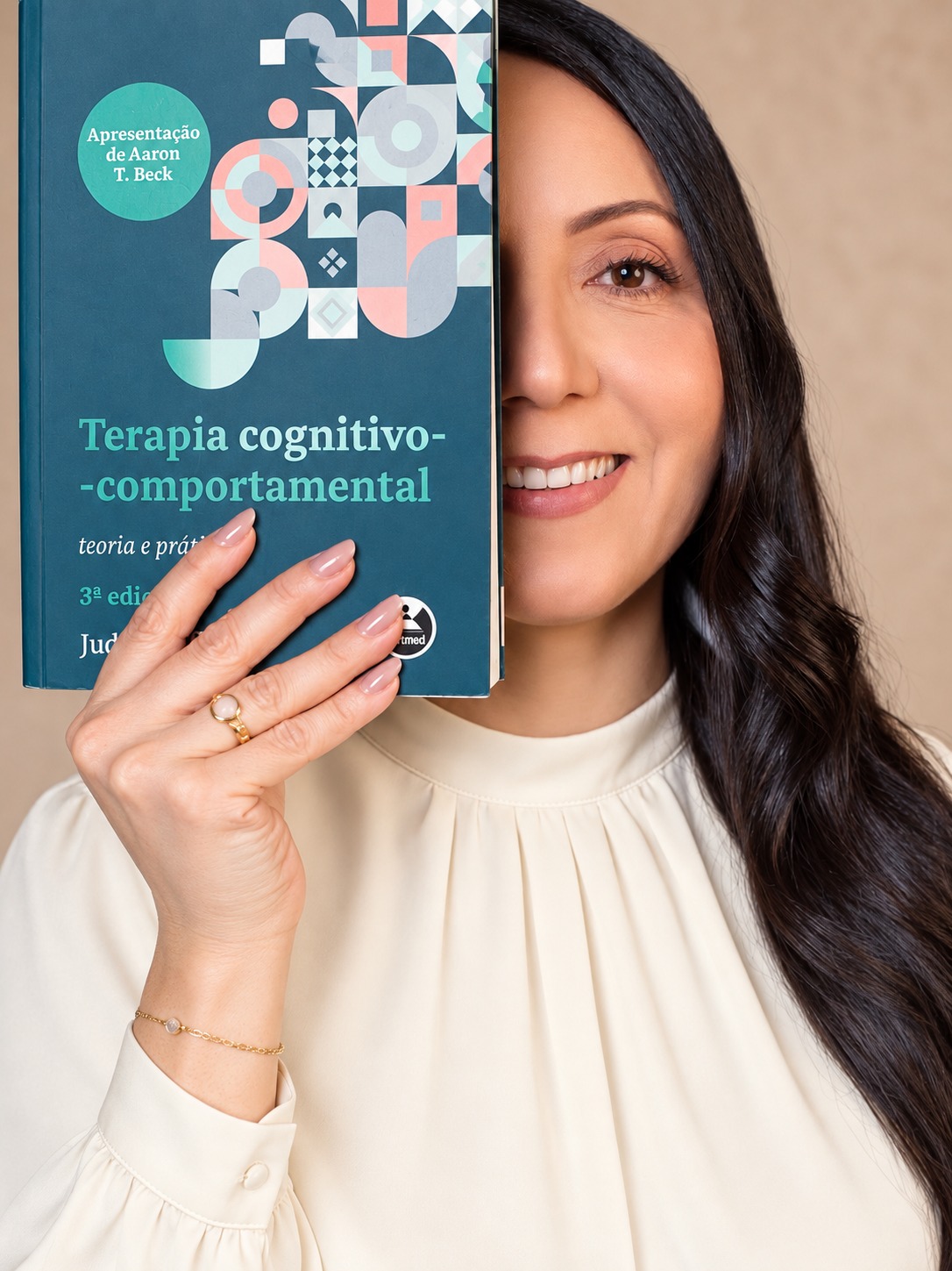 Kellen Paim segurando um livro de Terapia Cognitivo-Comportamental